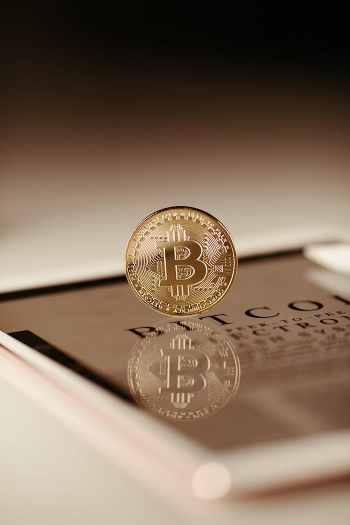 why-choose-us Close-up view of a Bitcoin coin reflecting on a tablet, symbolizing cryptocurrency technology.